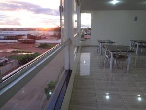 a balcony with a table and a view of the ocean at Golden Hotel in Vilhena