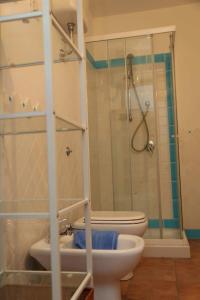 y baño con ducha, aseo y lavamanos. en B&B Tre en Oristano