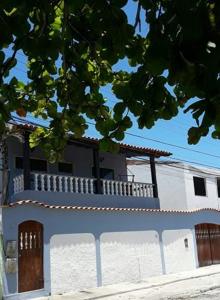 un edificio azul y blanco con balcón en Aconchego de um Lar Hospedagem Domiciliar, en Cabo Frío