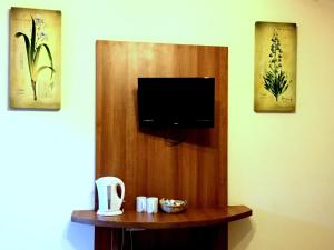 a room with a flat screen tv on a wall at The Oasis Hotel in Harlow