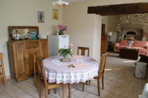 cocina con mesa, sillas y nevera en Chambre d'hôte Courtoux en Saint-Denis-sur-Sarthon