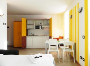 a room with a table and chairs and a kitchen at Residence Acero Rosso in Ponte di Legno