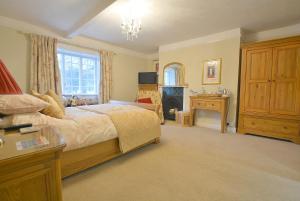 een grote slaapkamer met een bed en een open haard bij St Leonards Farmhouse in Blandford Forum