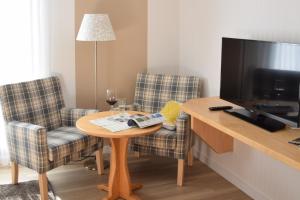 エスローエにあるForellenhof Poggelのテーブル、椅子2脚、テレビが備わる客室です。