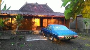 a blue car parked in front of a house at Rumah Limas in Yogyakarta