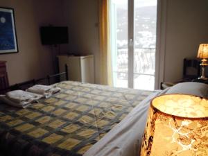 a bedroom with a bed with a blue blanket and a window at Blue Dolphin in Batsi
