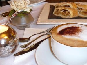 einen Tisch mit einer Tasse Kaffee und einem Teller Essen in der Unterkunft B&B Alla Loggia dell'Imperatore in Levico Terme