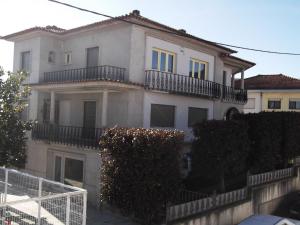a large white building with balconies on top of it at Sinos Rio Tinto in Campainha