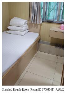 Habitación pequeña con cama con sábanas blancas. en Lung Wa Hotel, en Hong Kong