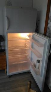 an empty refrigerator with its door open in a kitchen at Cottage Perla Vita in Le Cannet