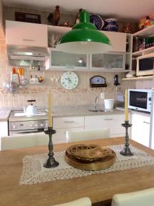a kitchen with a table with two candles and a clock at Edifício Afonso Delambert in Florianópolis