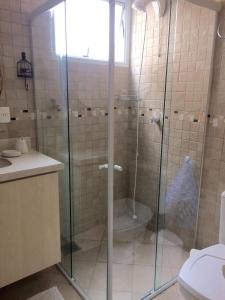 y baño con ducha de cristal y aseo. en Edifício Afonso Delambert, en Florianópolis