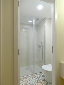 y baño con ducha de cristal y aseo. en FLH Douro View Luxury Duplex, en Oporto