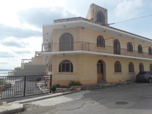 un edificio giallo con un balcone sopra di Felluga harbour view a Qala