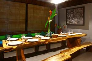 a wooden table with plates and glasses on it at Villa Kicen Ubud in Ubud