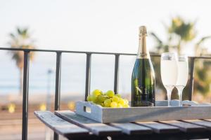 una mesa con una botella de champán y uvas en Vilasarmarlux II, en Vilassar de Mar