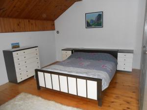 ein Schlafzimmer mit einem Bett und einer Kommode in der Unterkunft Apartman Draga in Mokra Gora