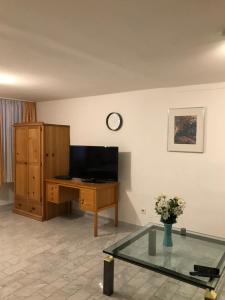 sala de estar con escritorio y reloj en la pared en Stadt Apartment, en Günzburg