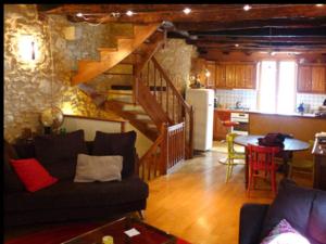 a living room with a staircase and a kitchen at Cosy maisonnette Lascaux in Montignac
