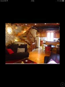 sala de estar con sofá y cocina en Cosy maisonnette Lascaux, en Montignac