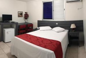 a hotel room with a bed and a tv at Oft Garden hotel in Goiânia