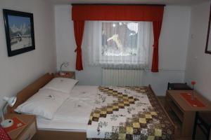 克拉尼斯卡戈拉apartma Albina的一间卧室，有一张床和一扇带红色窗帘的窗户