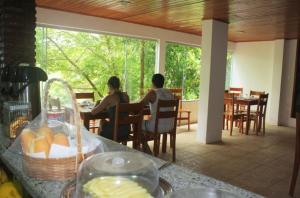 zwei Männer sitzen an einem Tisch in einem Restaurant in der Unterkunft Pousada Sereia Dourada in Itacaré