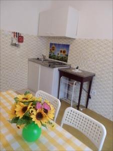 una cocina con una mesa con un jarrón de flores en APP Veselica, en Umag