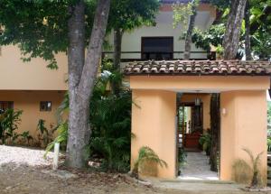 ein kleines Haus mit einer Veranda und einem Baum in der Unterkunft Pousada Sereia Dourada in Itacaré