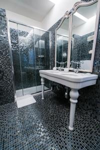bagno con lavandino e specchio di Hotel Antica Locanda a Roma
