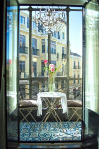 a table with a vase of flowers on a balcony at Purple Dog Suites in León