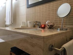 y baño con lavabo de mármol y espejo. en Atlantis Apartment, en Câmara de Lobos 20 fotos más