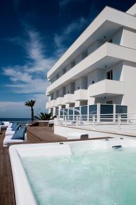 a hotel with a swimming pool in front of a building at AH Premium Isola di Pazze in Torre San Giovanni Ugento