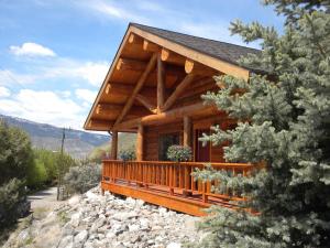 a large wooden cabin with a view of the mountains at The Roosevelt Hotel - Yellowstone in Gardiner