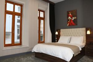 a bedroom with a large bed and two windows at Vita Suites Karaköy in Istanbul