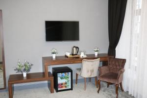 a room with a desk and a chair and a television at Vita Suites Karaköy in Istanbul