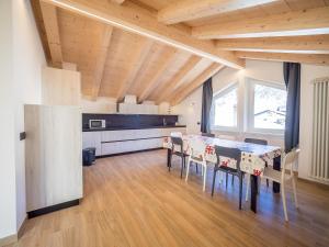 cocina y comedor con mesa y sillas en Apartments & Rooms MyHolidayLivigno en Livigno
