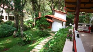 un jardin avec une petite maison blanche et quelques plantes dans l'établissement Recanto dos Kerr, à Monte Verde