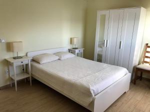 a bedroom with a white bed and a chair at Caravela in Perafita