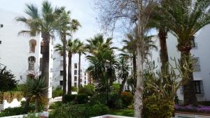eine Gruppe von Palmen vor einem Gebäude in der Unterkunft Appartement Punta Almina 100 m from t h e sea in San Luis de Sabinillas