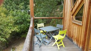 einen Tisch und Stühle auf einer Veranda einer Hütte in der Unterkunft La cabane du pommier in Orelle