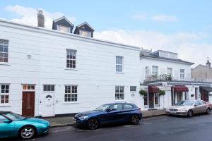 three cars parked in front of a white building at Great Loft & Location by Belsize Park tube in London