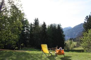 una persona sentada en una silla amarilla en un campo en Stillbacherhütte, en Mariahof