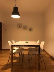 uma sala de jantar com uma mesa e cadeiras brancas em AZ El Balcón de Conde de Aranda II em Saragoça