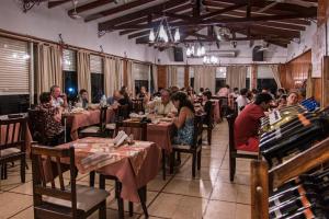 un gruppo di persone sedute ai tavoli di un ristorante di Hotel Parque Siquiman a Villa Carlos Paz