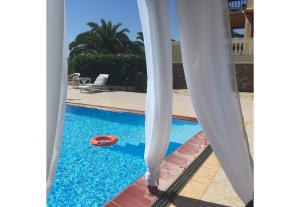 a person standing next to a swimming pool with two surfboards at Alonissos Muses Villas in Kalamakia