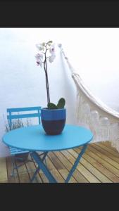 een blauwe tafel met een bloem in een pot erop bij Santo Amaro's House in Lissabon