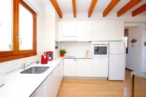 a white kitchen with a sink and a refrigerator at Sant Miquel Homes - Turismo de interior in Palma de Mallorca
