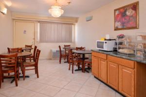 a dining room with tables and chairs and a microwave at Americas Best Value Inn-Pittsburgh Airport in Coraopolis