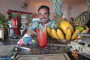 a man sitting at a table with bananas and fruit at Canto das Laranjeiras Tombo in Guarujá